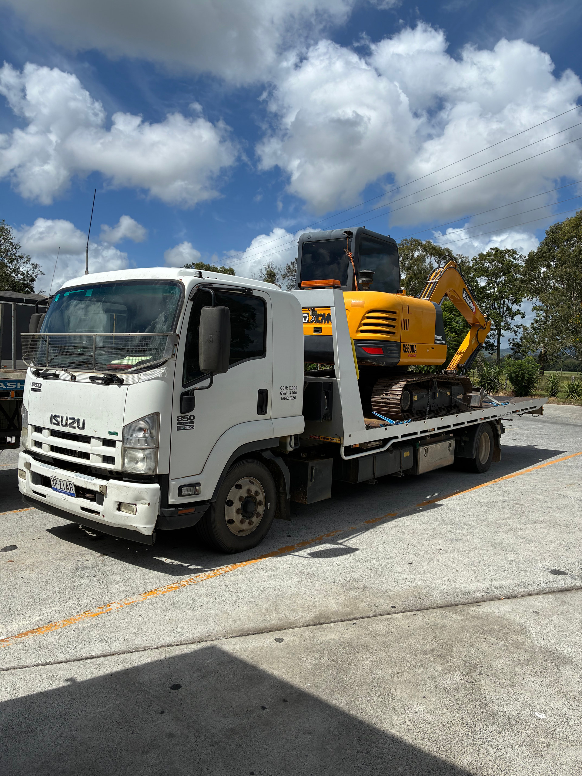Excavator being transported on the back of our tow truck