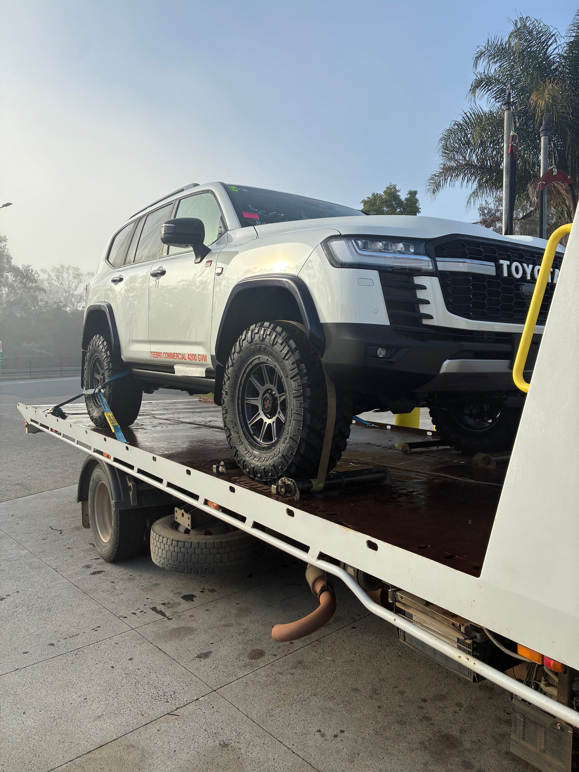 White Toyota Prado on back of tilt tray